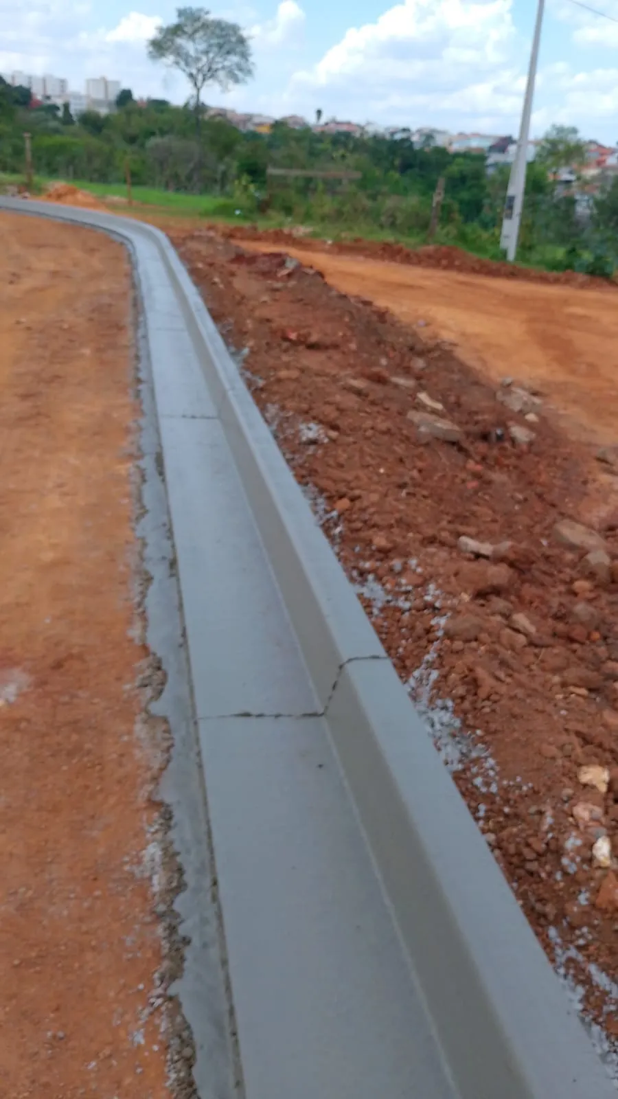 Guia e sarjeta de concreto acompanhando o traçado curvo de uma via